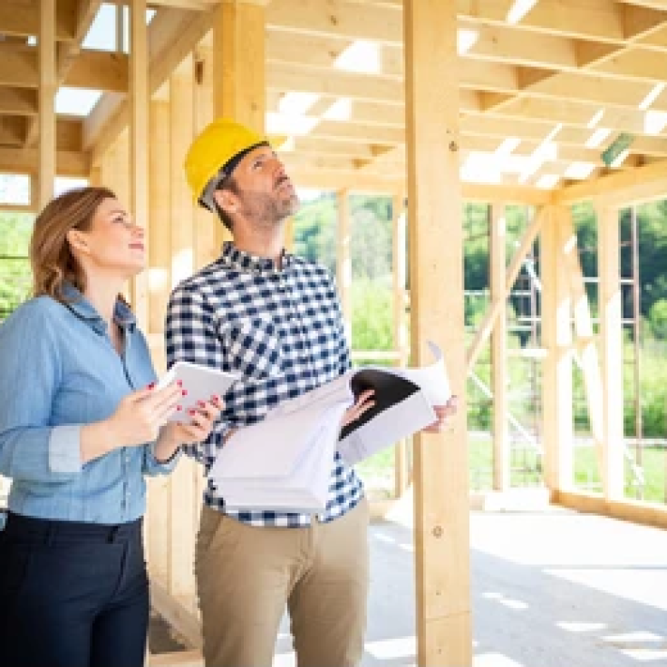 female-homeowner-consults-blueprints-architect-260nw-1772742209